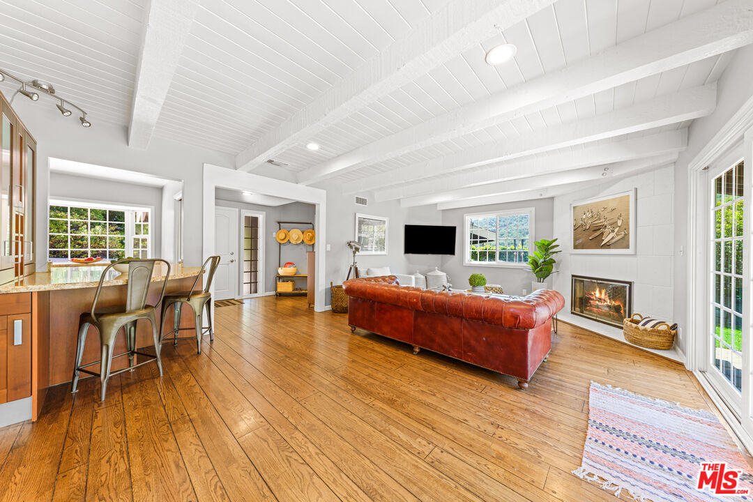 3940 Mandeville Canyon Road Los Angeles, CA 90049 - Photo 8 of 54 a living room with furniture and a wooden floor