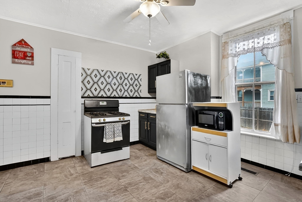 55 Florida Street Springfield, MA 01109 - Photo 17 of 42 a kitchen with stainless steel appliances kitchen island granite countertop a refrigerator and a stove top oven