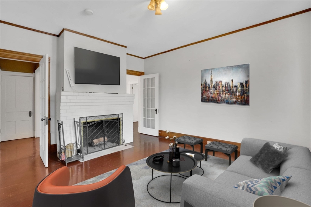 55 Florida Street Springfield, MA 01109 - Photo 8 of 42 a living room with furniture a flat screen tv and a fireplace