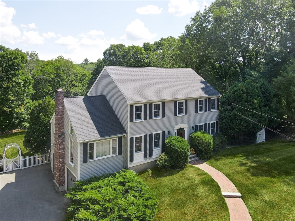 a aerial view of a house next to a big yard and large trees