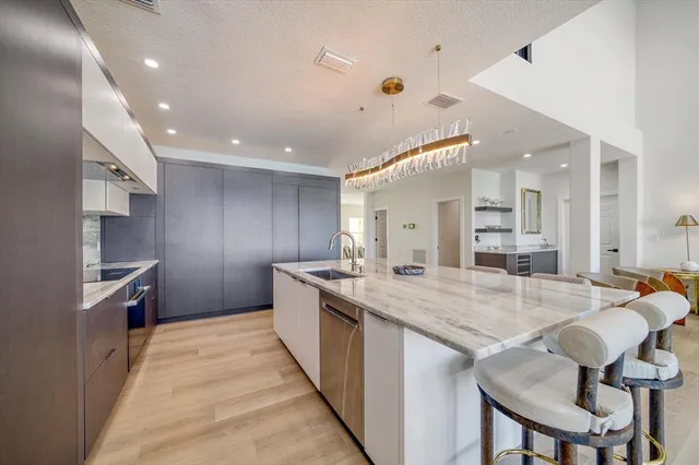 a kitchen with stainless steel appliances kitchen island granite countertop a dining table and chairs