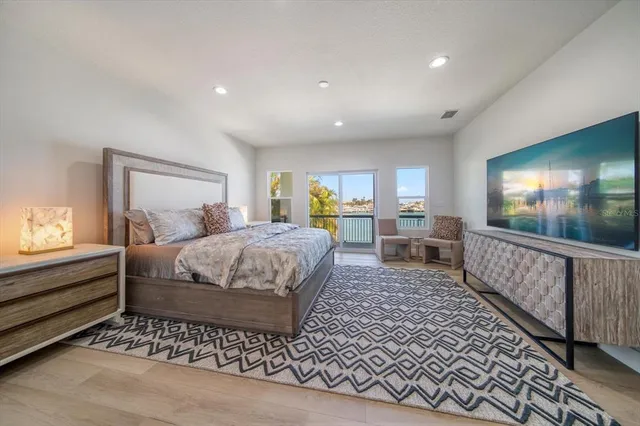 a spacious bedroom with a bed and a painting on the wall