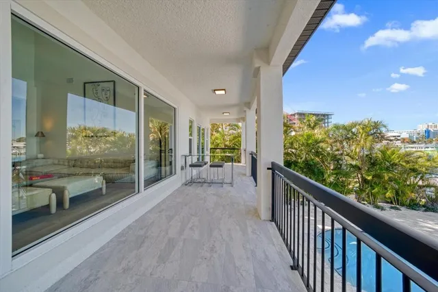 a view of a swimming pool with a yard and large trees