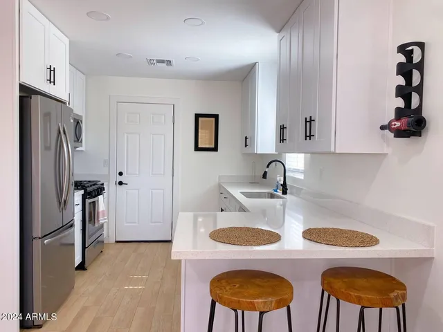 a kitchen with stainless steel appliances granite countertop a sink and a refrigerator