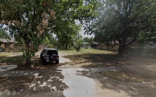 a view of a yard with large trees