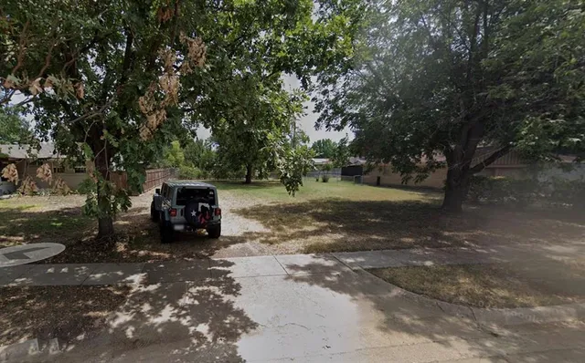 a view of a yard with large trees