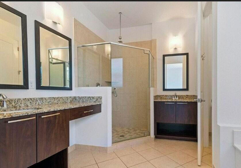 4858 Northwest 16th Terrace Boca Raton, FL 33431 - Photo 13 of 38 a bathroom with a granite countertop sink a mirror and shower