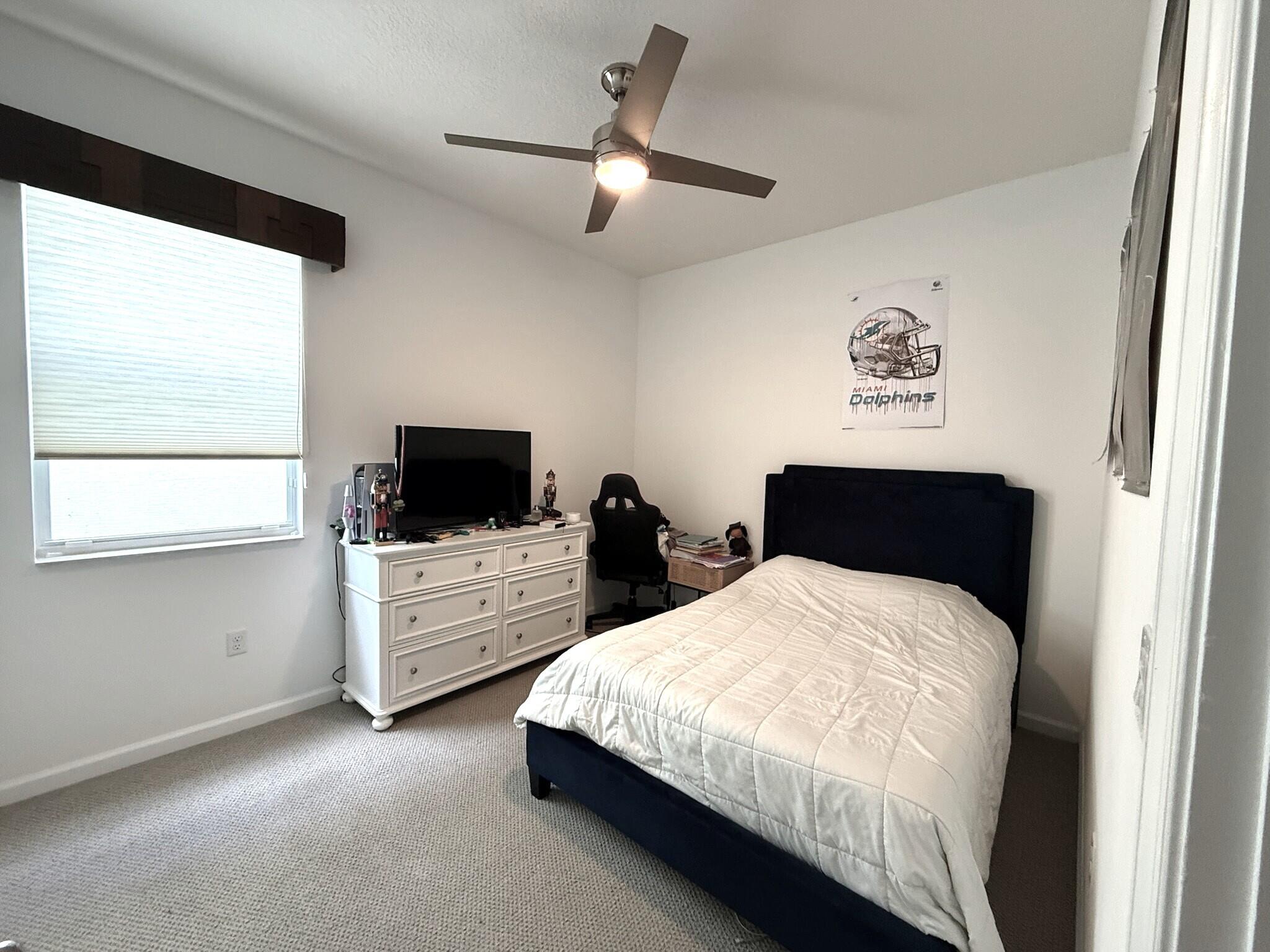 4858 Northwest 16th Terrace Boca Raton, FL 33431 - Photo 16 of 38 a spacious bedroom with a bed and a flat screen tv