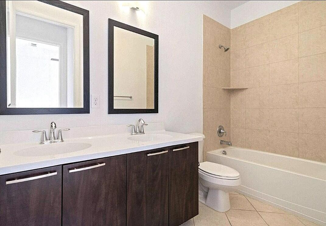 4858 Northwest 16th Terrace Boca Raton, FL 33431 - Photo 19 of 38 a bathroom with a double vanity sink toilet mirror and bathtub