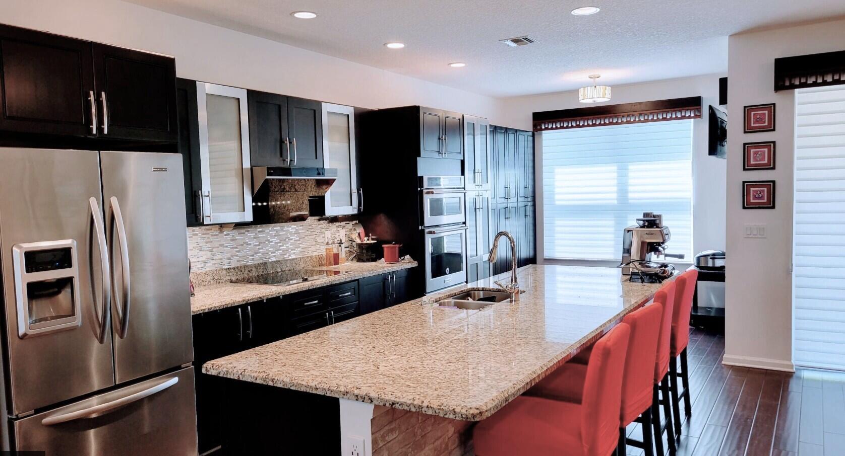 4858 Northwest 16th Terrace Boca Raton, FL 33431 - Photo 6 of 38 a kitchen with stainless steel appliances granite countertop a refrigerator a sink a stove a microwave and island