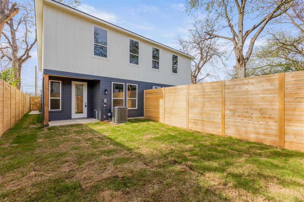 3526 Spring Avenue Dallas, TX 75210 - Photo 26 of 27 Back of house with board and batten siding, a fenced backyard, and a patio area