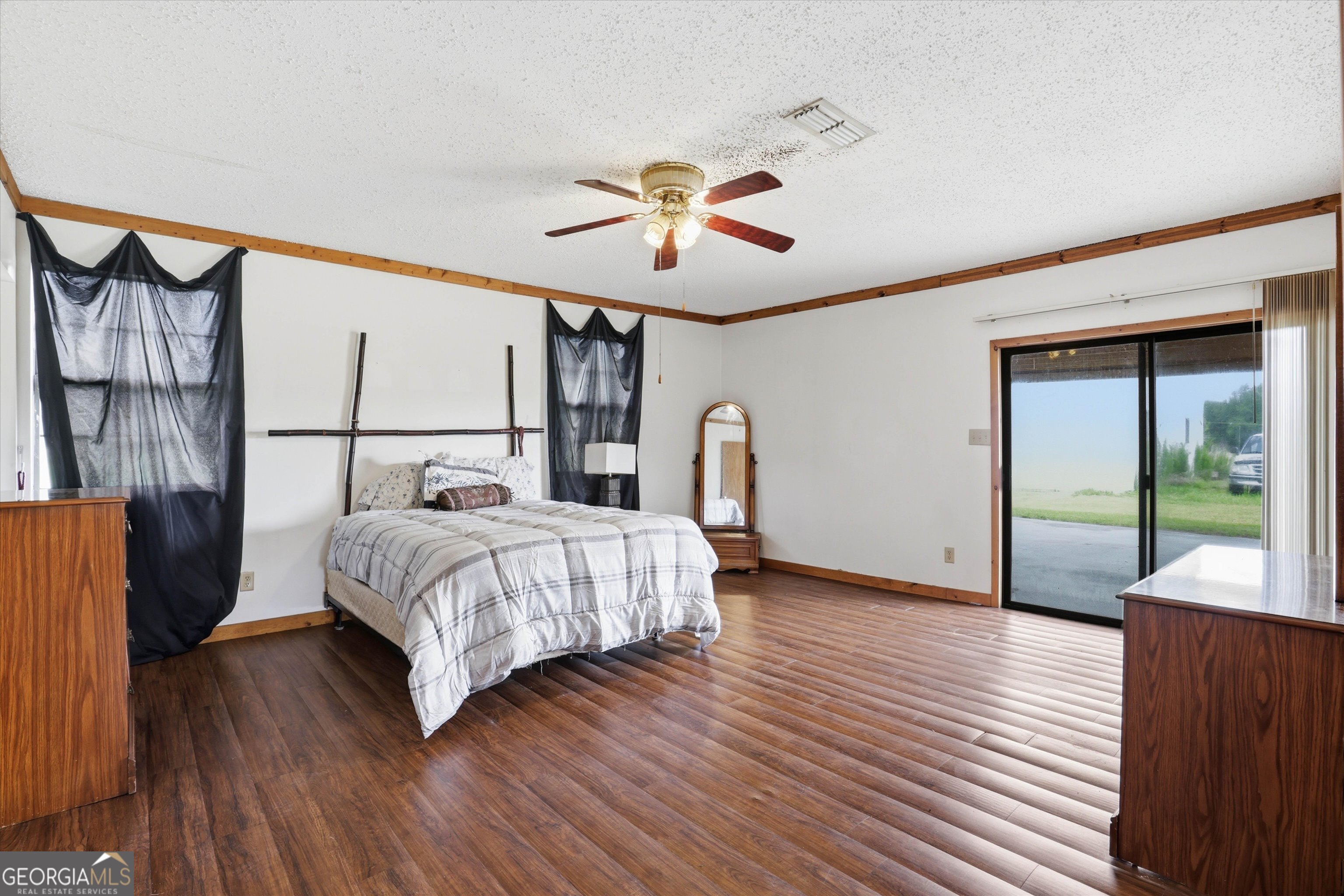 1525 Myron Hart Road Coolidge, GA 31738 - Photo 18 of 58 a bedroom with a bed and a chandelier