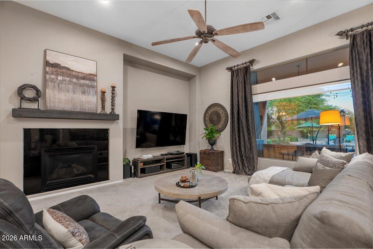 6427 South Magic Court Gilbert, AZ 85298 - Photo 23 of 71 a living room with furniture a fireplace and a flat screen tv