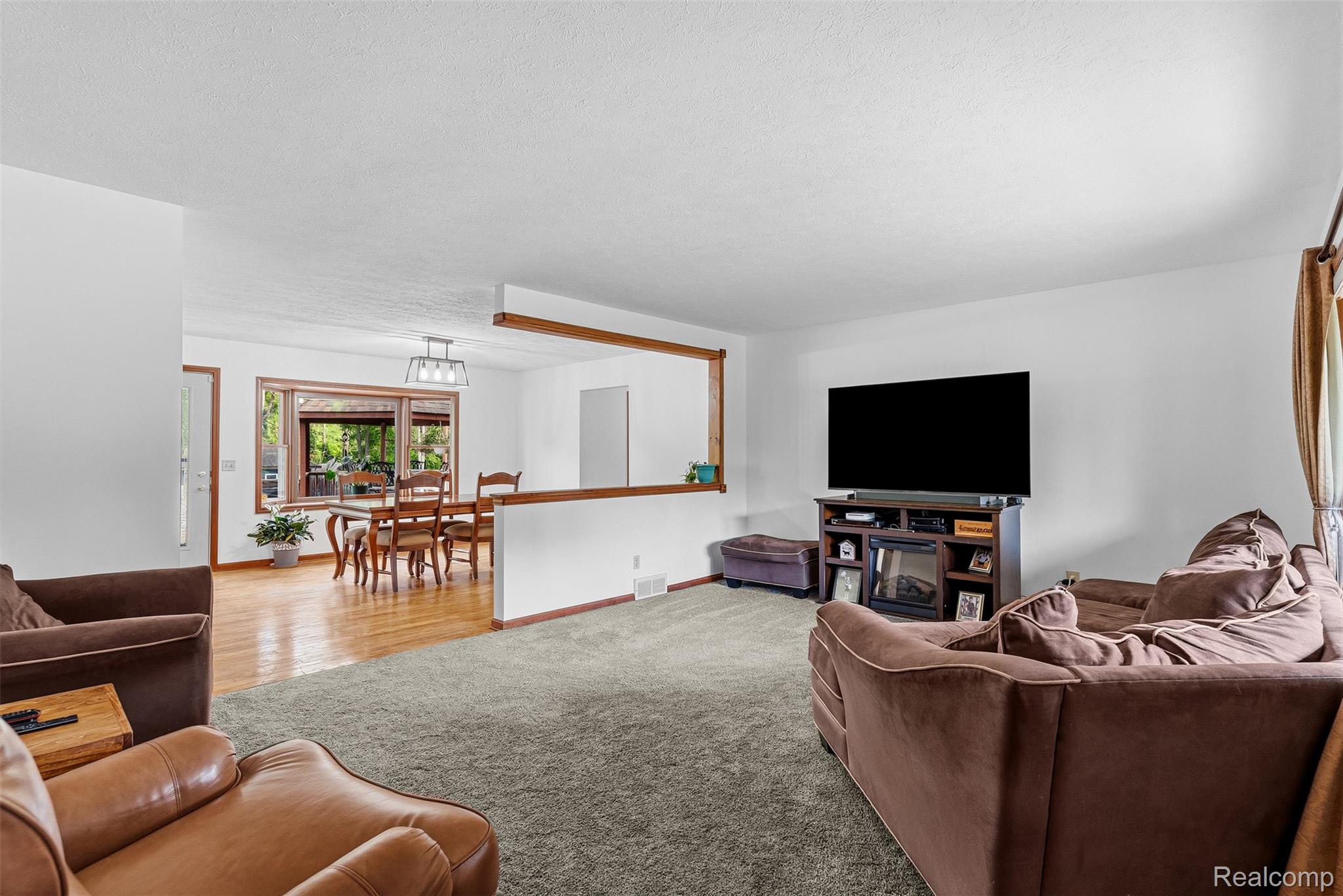 6699 Lansing Road Durand, MI 48429 - Photo 7 of 53 Open-concept living area with plush carpeting and natural light