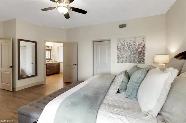 a bedroom with a large bed and ceiling fan