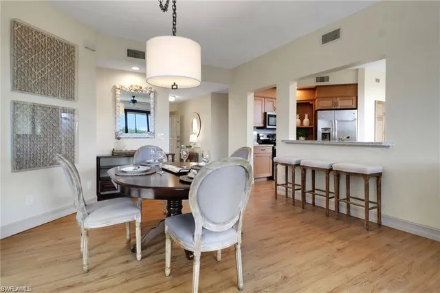 a dining room with wooden floor a chandelier a wooden table and chairs