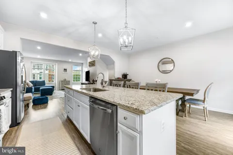 a large kitchen with kitchen island a large counter space a sink appliances and living room view