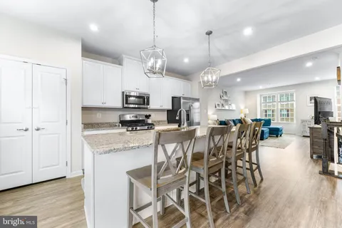a view of a dining area with furniture a kitchen and chandelier