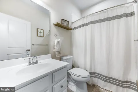 a bathroom with a sink toilet vanity and shower
