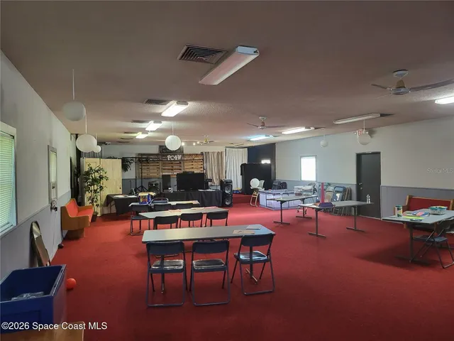 a view of a dining room with furniture and a chandelier