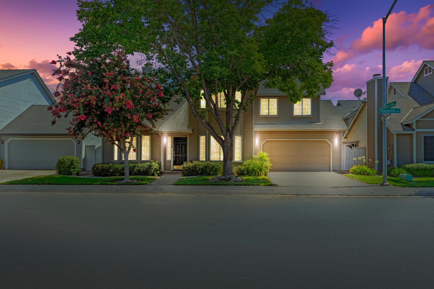 a front view of a house with a garden and tree