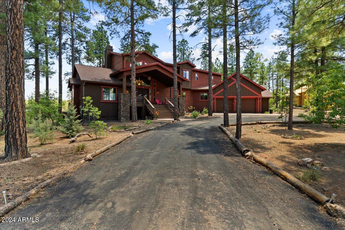 4051 West Falling Leaf Road Show Low, AZ 85901 - Photo 14 of 77 a view of a wooden house with a bench and trees