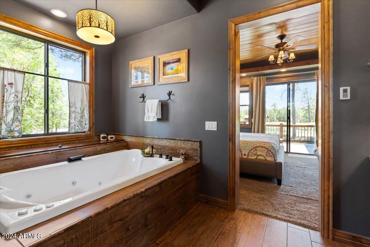 4051 West Falling Leaf Road Show Low, AZ 85901 - Photo 45 of 77 a spacious bedroom with a bed and a chandelier