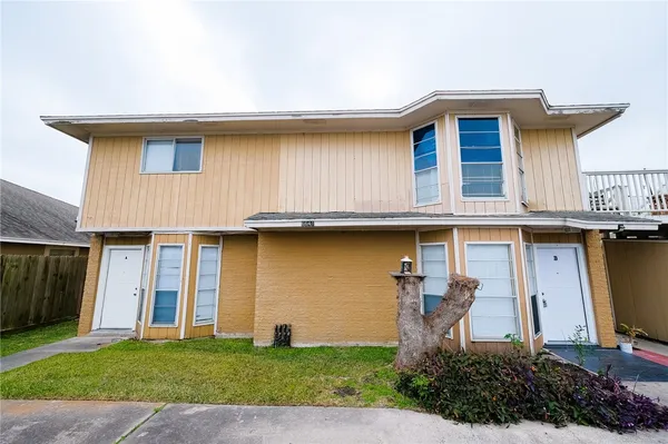 a front view of a house with a garden and garage