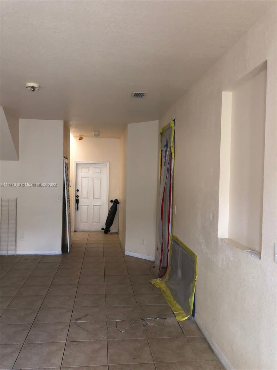 100 Southwest 15th Road, Unit 100 Homestead, FL 33030 - Photo 4 of 25 a view of a hallway with entryway to a bedroom