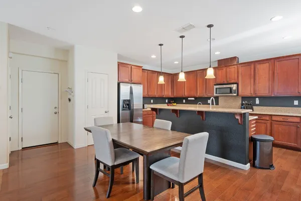 a kitchen with stainless steel appliances granite countertop a kitchen island a stove a table and chairs