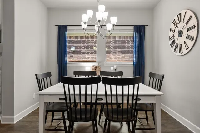 a view of a dining room with furniture a chandelier and wooden floor