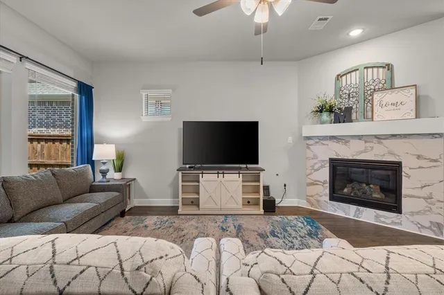 a living room with furniture a flat screen tv and a fireplace