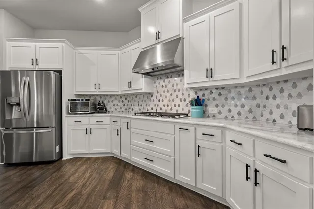 a kitchen with white cabinets white stainless steel appliances and sink