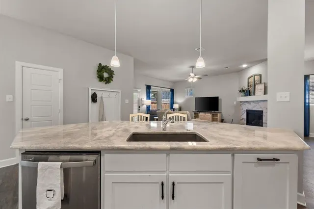 a view living room with kitchen island a sink and wooden floor