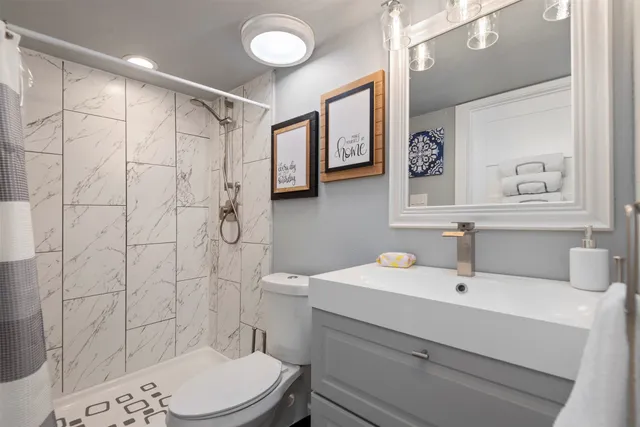 a bathroom with a sink a toilet and shower