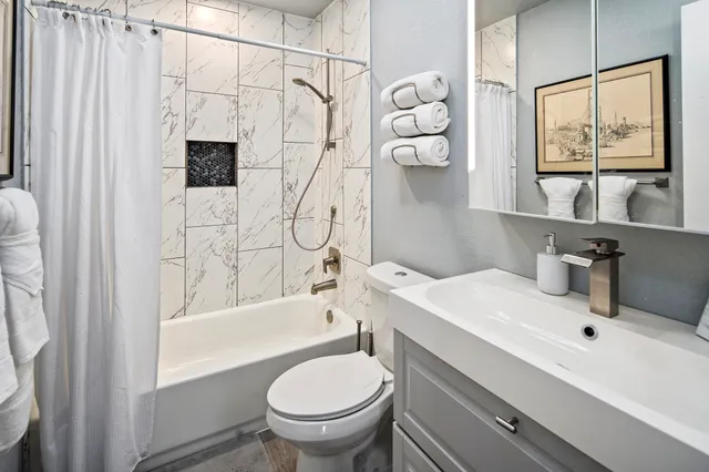 a bathroom with a sink toilet and shower