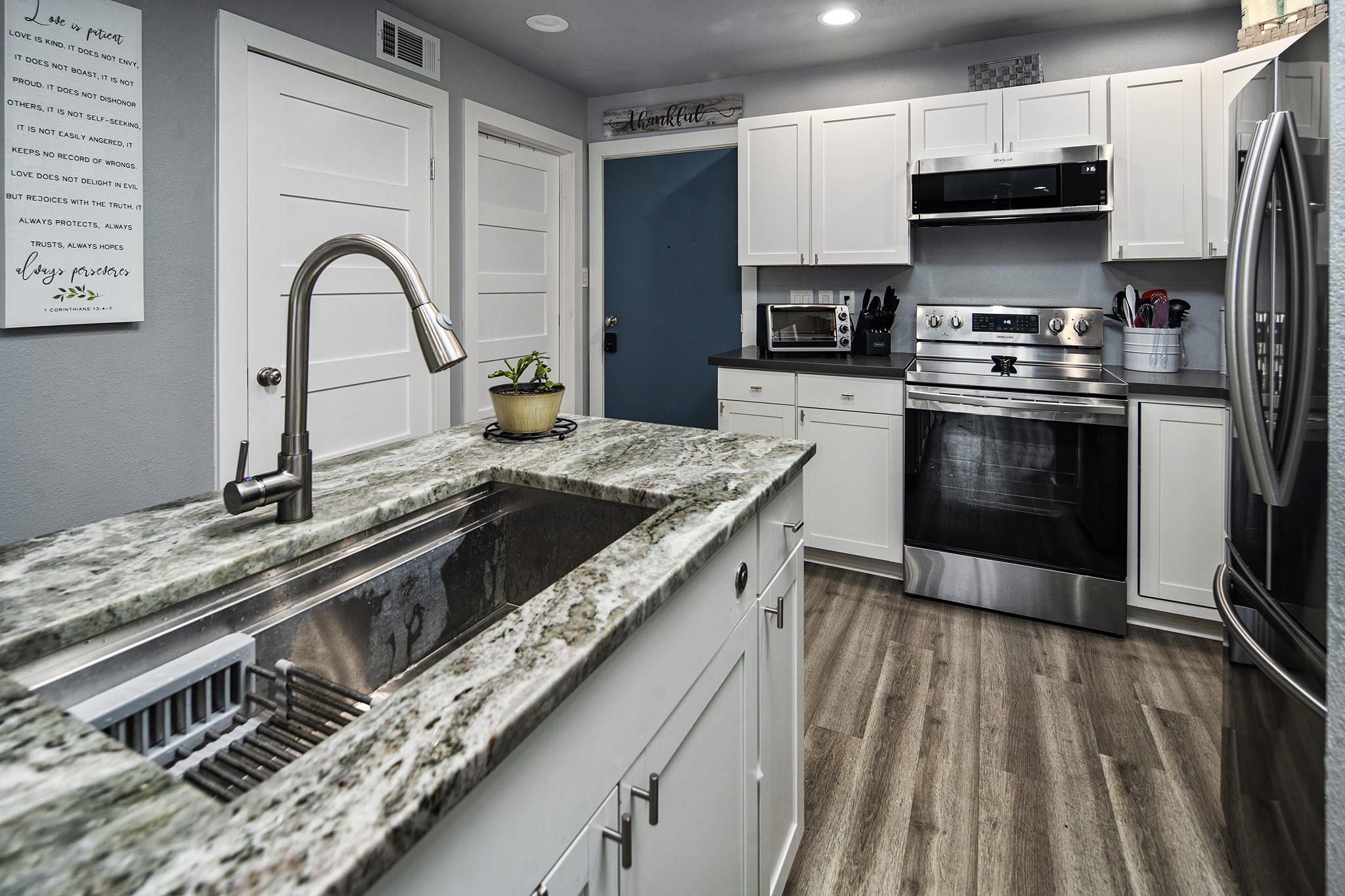 13151 Walden Road, Unit 195 Montgomery, TX 77356 - Photo 2 of 35 a kitchen with stainless steel appliances granite countertop a stove a sink and a microwave
