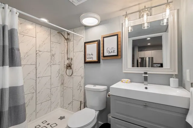 a bathroom with a sink toilet and shower