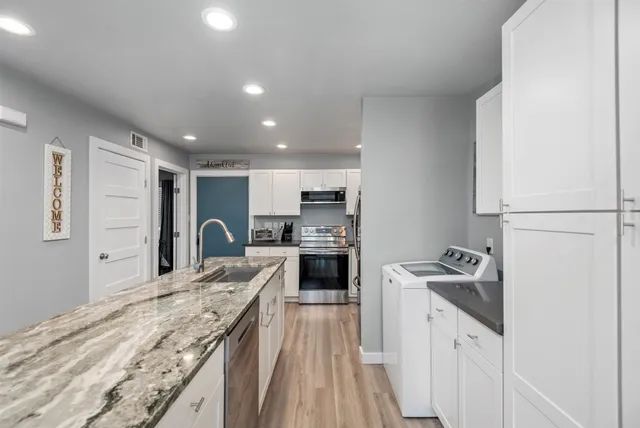 a kitchen with granite countertop a sink stove and refrigerator