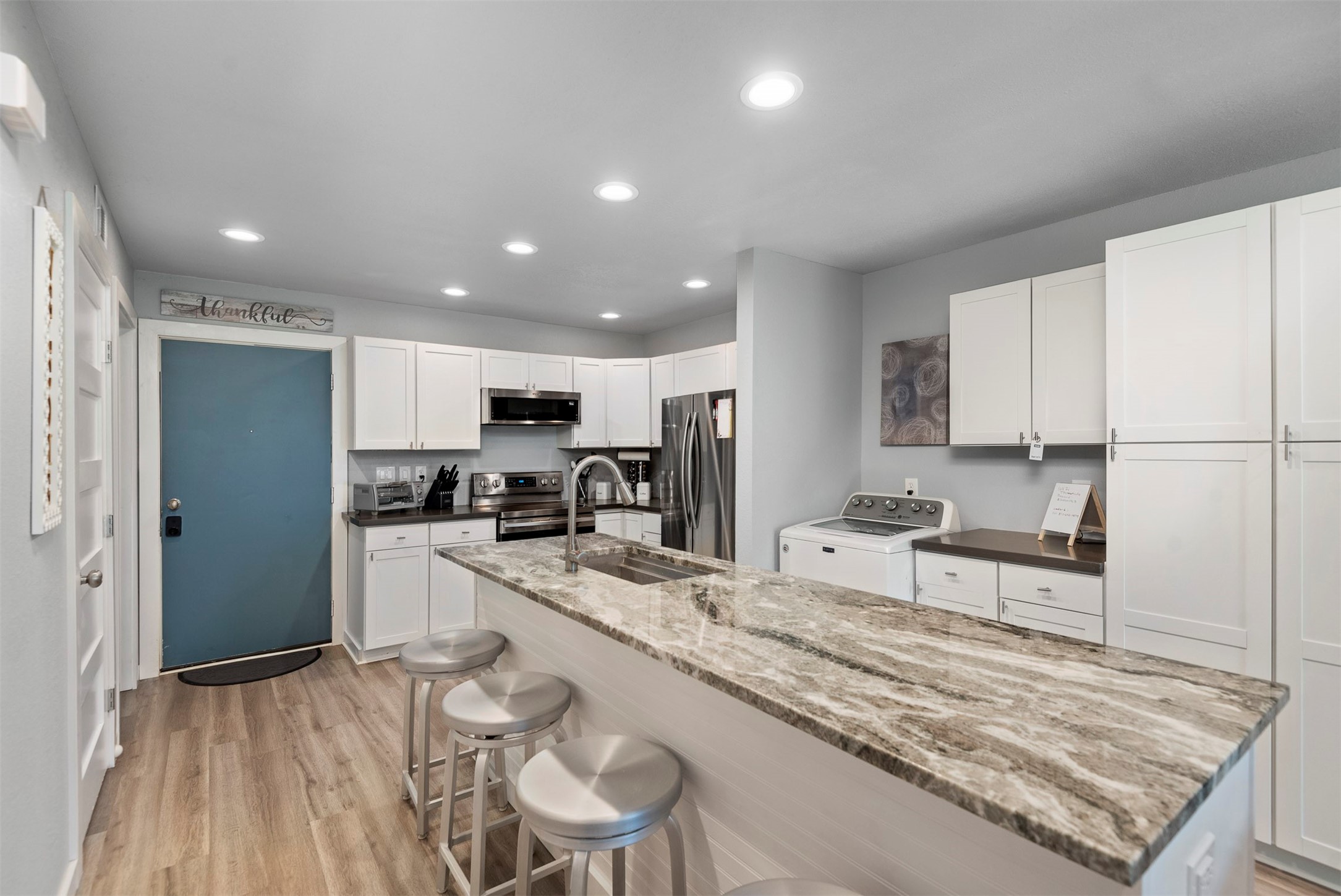 13151 Walden Road, Unit 195 Montgomery, TX 77356 - Photo 5 of 35 a large kitchen with kitchen island a sink stove and white cabinets