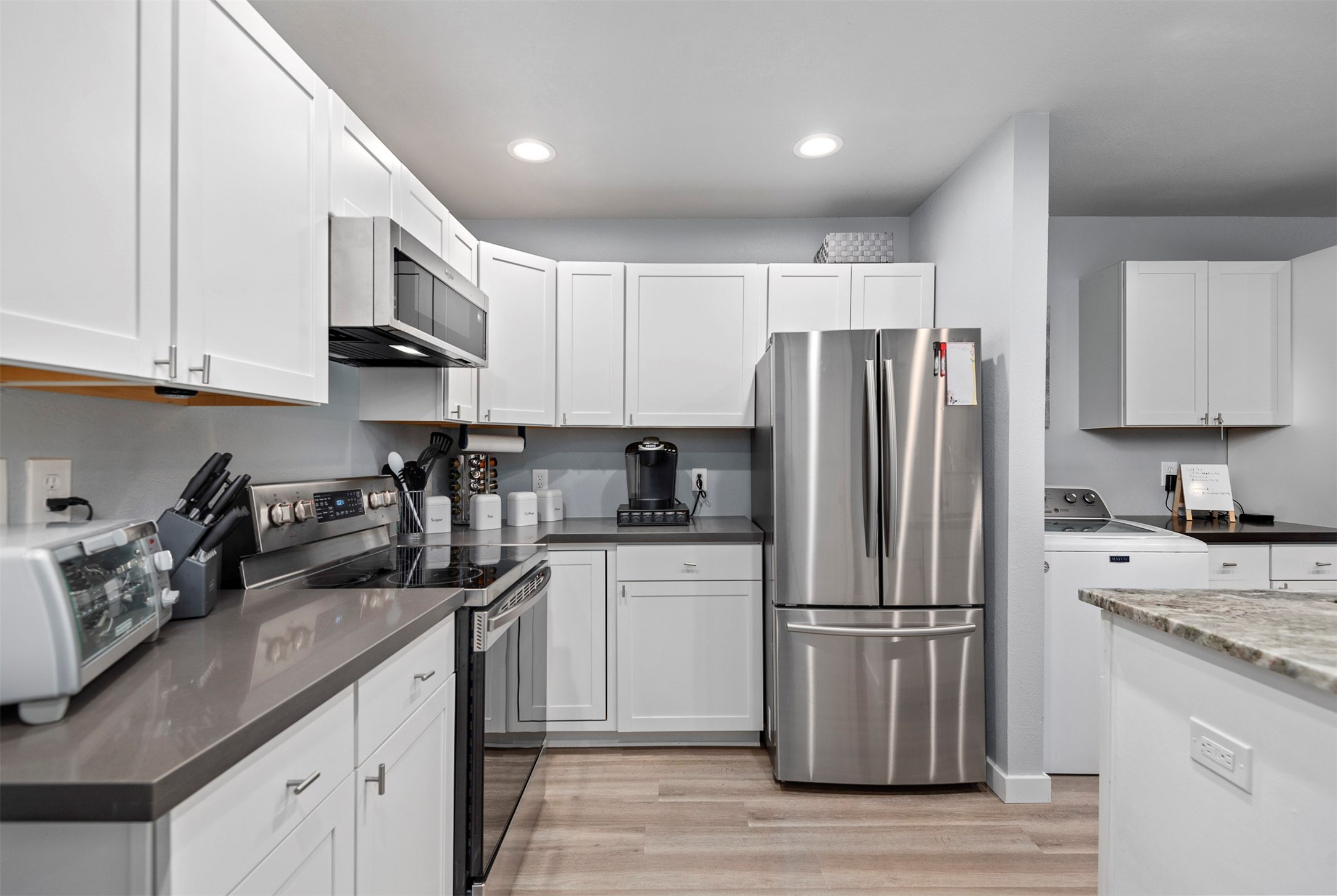 13151 Walden Road, Unit 195 Montgomery, TX 77356 - Photo 6 of 35 a kitchen with granite countertop a refrigerator stove and sink with wooden floor