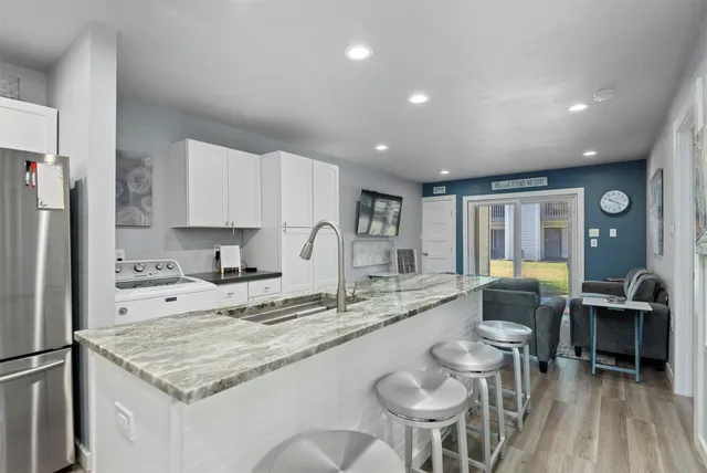 a kitchen with stainless steel appliances granite countertop a sink and a refrigerator