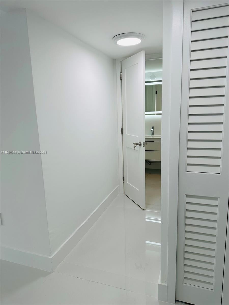 345 Ocean Drive, Unit 219 Miami Beach, FL 33139 - Photo 22 of 26 a view of a hallway with bathroom and a sink