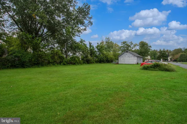a view of a green field with house in the background