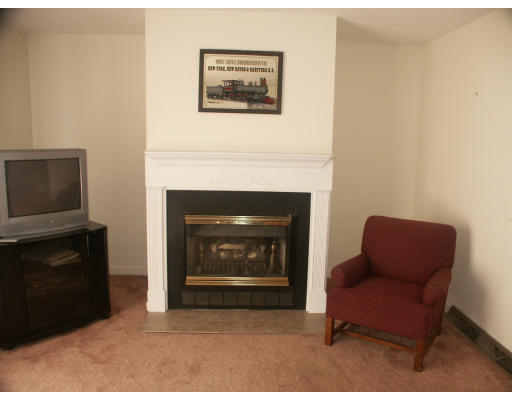 10 Shellback Way, Unit 10 Mashpee, MA 02649 - Photo 6 of 12 a living room with furniture a flat screen tv and a fireplace