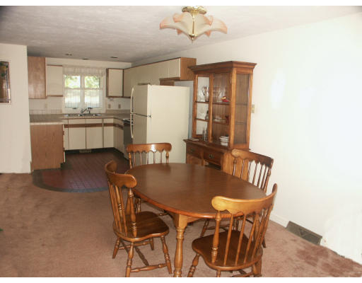 10 Shellback Way, Unit 10 Mashpee, MA 02649 - Photo 7 of 12 a kitchen with a dining table chairs and refrigerator