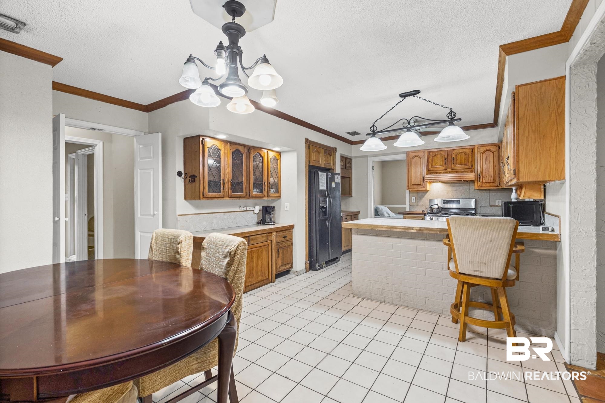 5510 Richmond Road Mobile, AL 36608 - Photo 5 of 21 Kitchen featuring wood cabinetry, white tile flooring, white brick-textured breakfast bar, and recessed lighting