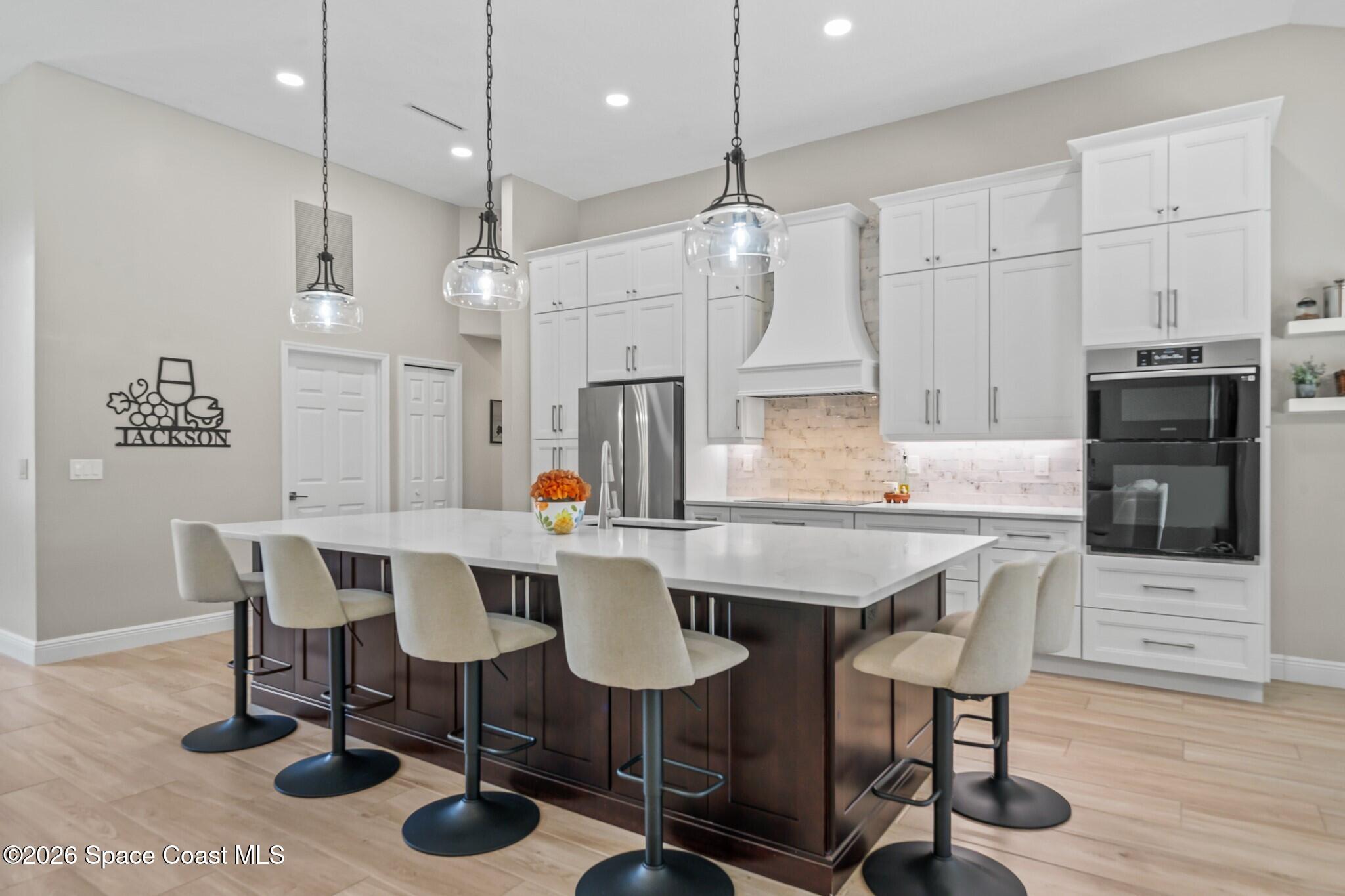 697 Spring Lake Drive Melbourne, FL 32940 - Photo 11 of 45 a view of a dining room with furniture a kitchen and chandelier