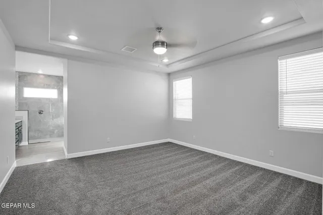 an empty room with fan and windows
