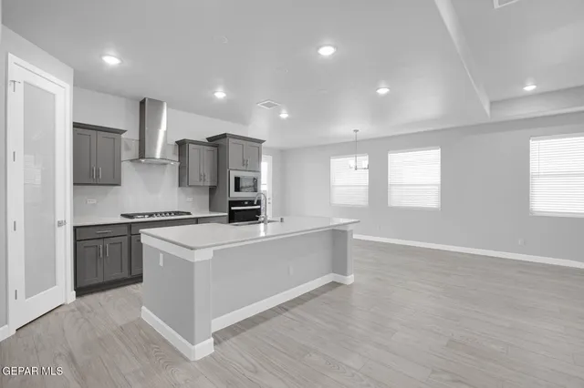 a kitchen with stainless steel appliances granite countertop a stove a sink and a refrigerator